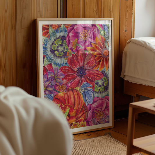 Framed colorful floral artwork leaning on a wooden wall next to a bed