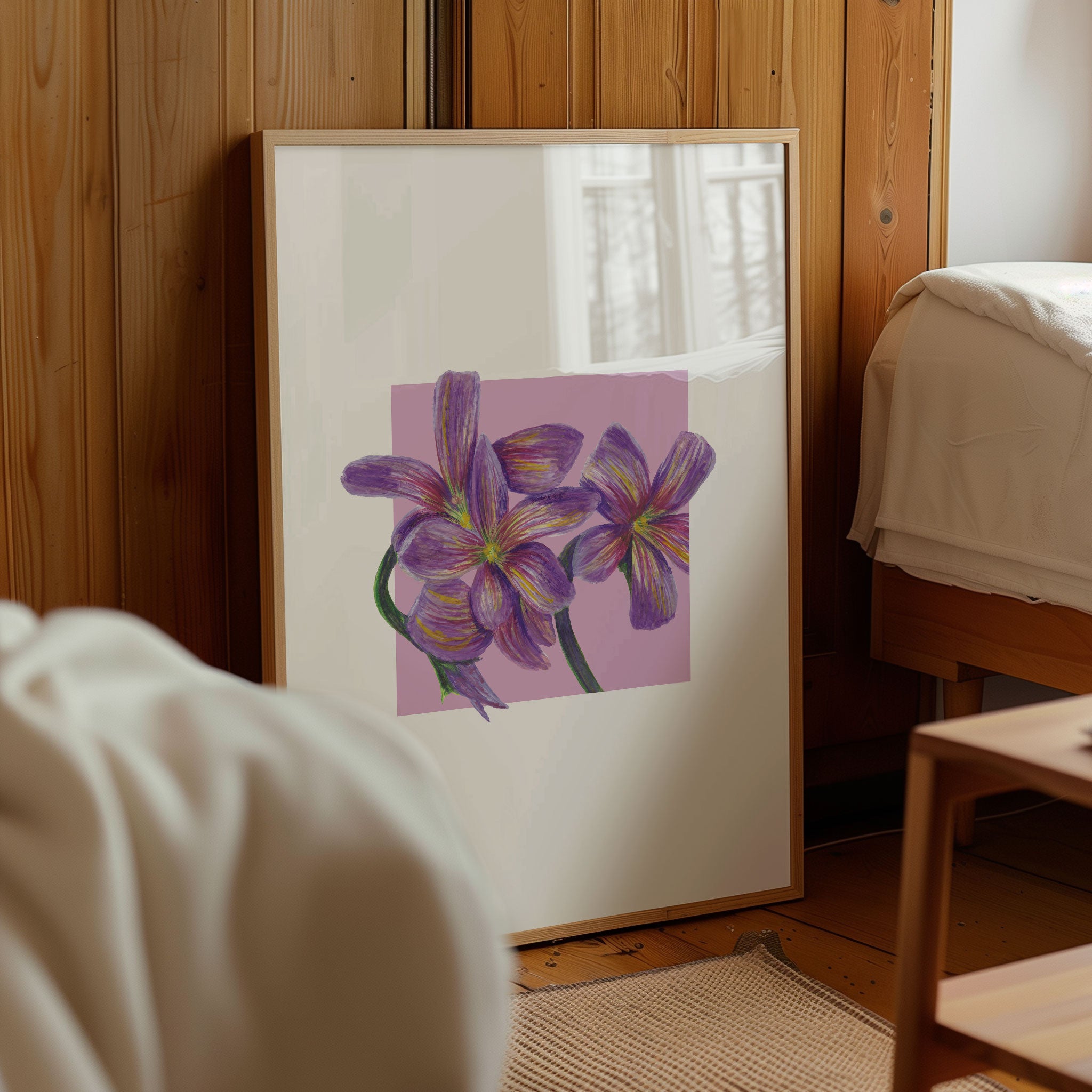 Framed artwork of purple flowers on a wall in a room with wooden paneling.