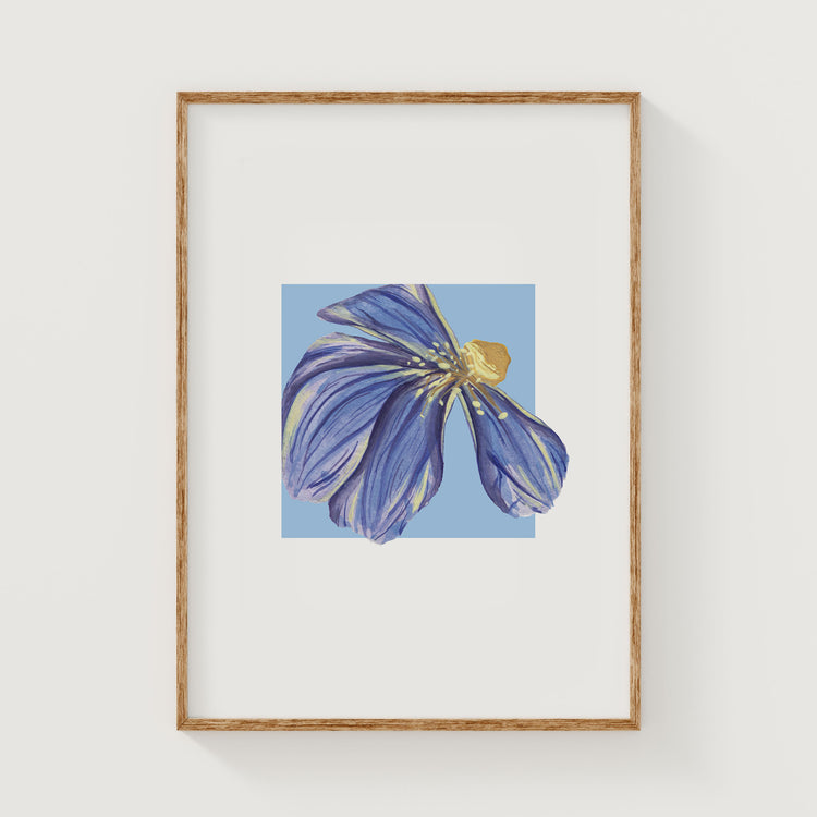 Framed artwork of a blue dune flower on a white wall