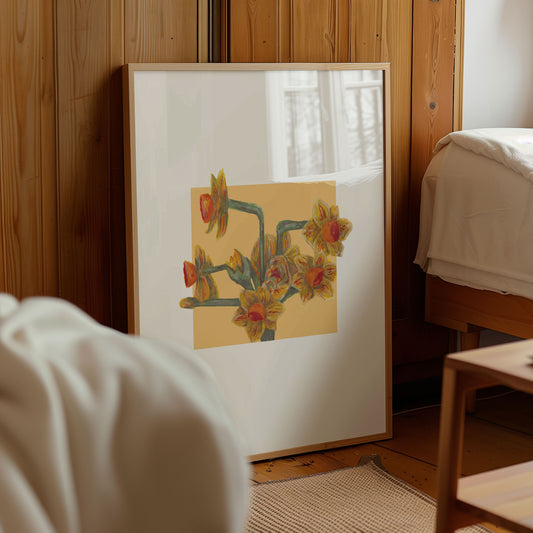 Framed artwork of yellow daffodil flowers on a wall in a room with wooden paneling.